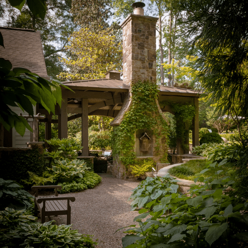 Large outdoor living area with gazebo and fireplace, filled with shade plants like ferns and hosta