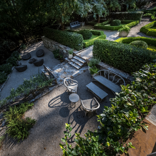 Outdoor seating areas with neatly trimmed hedges and formal garden